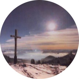 Ein verschommenes Bild eines Gipfelkreuz.